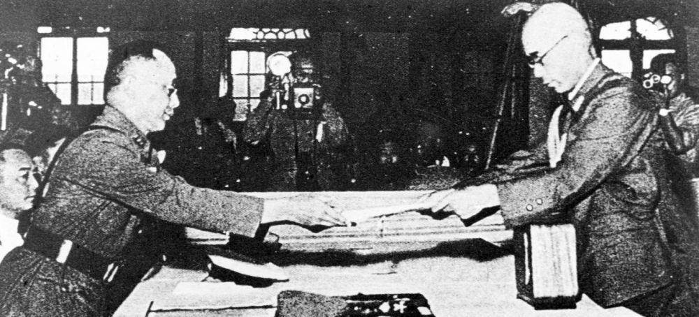 1945年9月9日，何应钦（左）在南京代表中国政府接受侵华日军总参谋长小林浅三郎递交的侵华日军总司令冈村宁次签署的投降书。新华社发